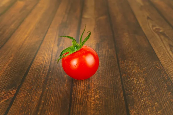 木桌上的一个新鲜的红番茄 — 图库照片