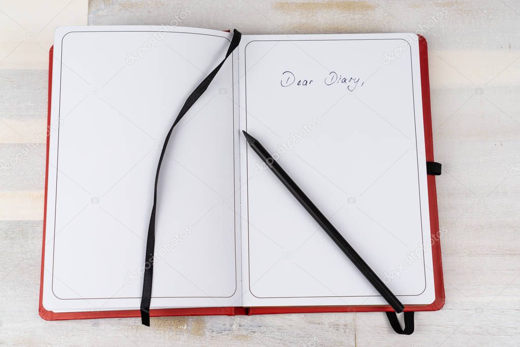 Diary with a black pen, copy space and the words Dear Diary
