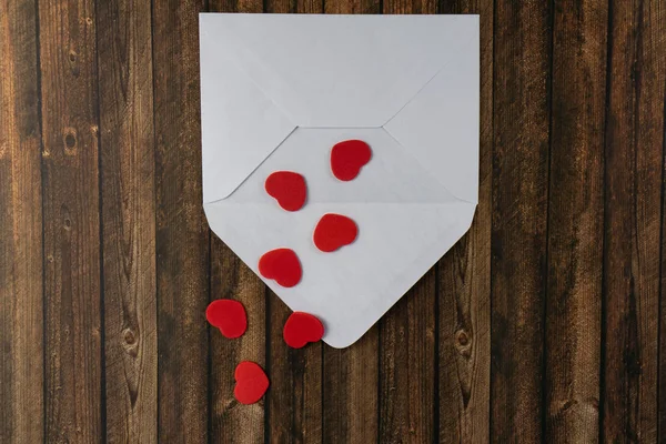 赤いハートの白い封筒 背景に木製のテーブル — ストック写真