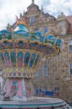 Eski tarihi bir binanın önünde kimse ile Swing Carousel