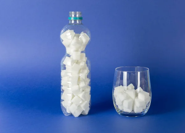 Uma Garrafa Plástico Copo Água Com Cubos Açúcar Fundo Azul — Fotografia de Stock
