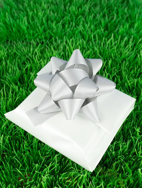 Ein Weiß Verpacktes Geschenk Mit Einer Silbernen Schleife Auf Einer — Stockfoto