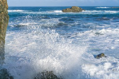 İspanya, Tenerife yakınlarındaki dalgalı Atlantik Okyanusu, sudaki kayalıklarda güçlü dalgalar kopuyor.