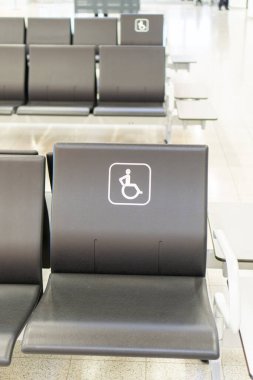 Siyah sandalyeli koltuklar, bu koltuğun sadece engelliler için olduğunu gösteriyor.