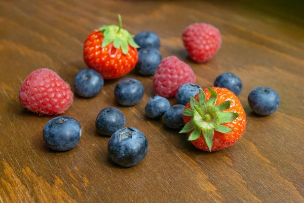 Fresas Frambuesas Arándanos Yacen Sobre Una Mesa Madera — Foto de Stock