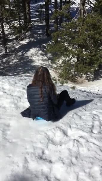 Teenager-Mädchen beim Rodeln einen verschneiten Hügel hinunter. glückliche Mädchen bewegen sich auf einer Schlitten, Eisscholle. Spaß im Winterurlaub. Teenager Mädchen führt Hügel hinunter, Schlittenfahrt durch Schnee. — Stockvideo