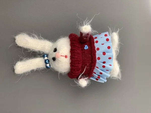 Handmade knitted toy. Easter Bunny in red sweater with and blue skirt. Rabbit christmas toy. hare
