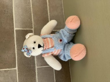 Örme şirin oyuncak ayı oyuncak masada oturan kostüm.