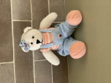 Örme şirin oyuncak ayı oyuncak masada oturan kostüm.