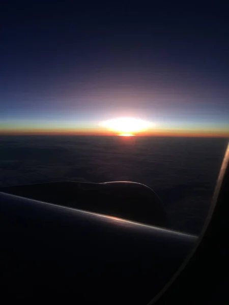 Vacker solnedgång eller soluppgång himmel ovanför moln med dramatiskt ljus. utsikt från flygplan — Stockfoto
