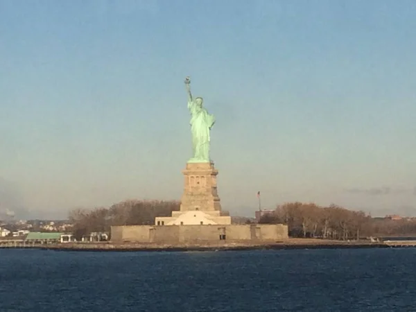 Minimale zeegezicht uitzicht op het standbeeld van Liberty silhouet in de horizon, brede blauwe en gele mistige hemel in de achtergrond, Staten Island, Manhattan, New York, Amerika, USA. — Stockfoto