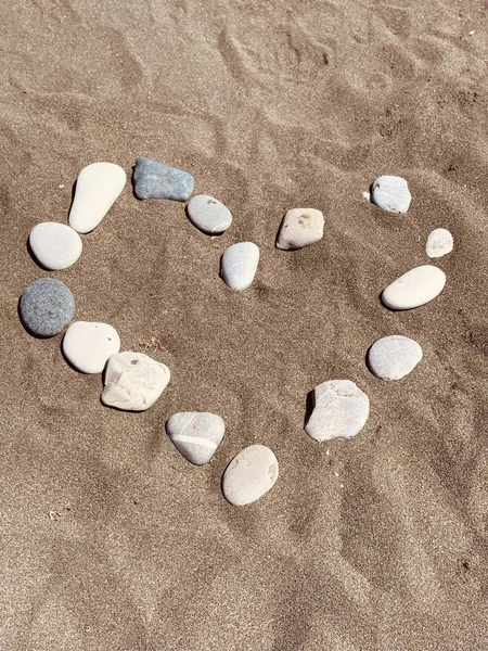 Corazón de las piedras en la playa de arena — Foto de Stock
