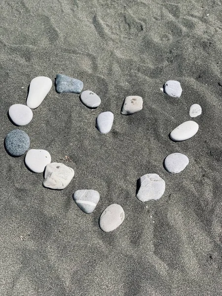 Corazón de las piedras en la playa de arena — Foto de Stock