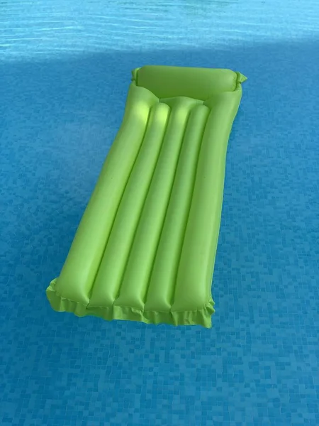 Зелений надувний матрац, що плаває на поверхні води — стокове фото
