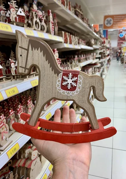 Vintage viejo caballo de madera mecedora Navidad decoración clásica en la mano femenina — Foto de Stock