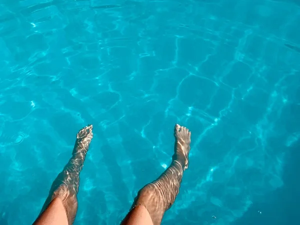 閉じる 子供の足の結晶澄んだ青い水のプールの上に座っている 夏休みリラックス — ストック写真