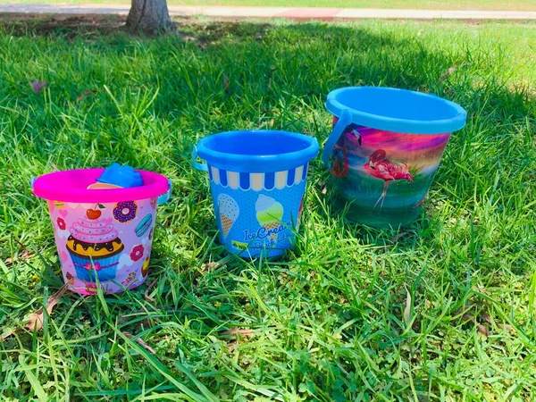 Cubos de plástico para niños de color sobre el fondo de hierba verde . — Foto de Stock