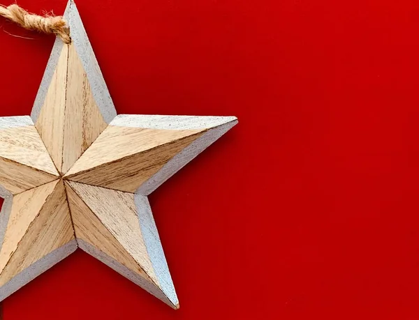 Background with wooden Christmas decorations star on red background. Space for text. — Stock Photo, Image