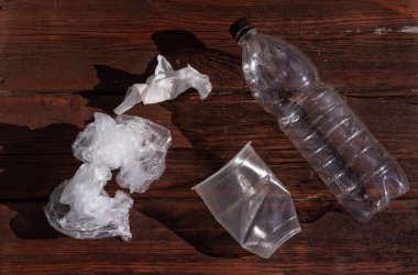 Plastik cam ve şişe. Koyu ahşap arka planda bir Celenfa paketi..