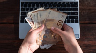 İş ve finans. Serbest masaüstü bilgisayarı. Ahşap arka planda gri bir dizüstü bilgisayar. İş yeri, evden çalışma.