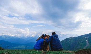 Koruldi 'nin dağ gölleri. Kafkas dağları. Karlı dağların zirveleri bir ayna gibi dağ gölüne yansıyor. Bir kız ve bir adam köpekle birlikte Georgia, Svaneti dağlarında oturuyorlar. Alman çoban köpeğini gezdir..