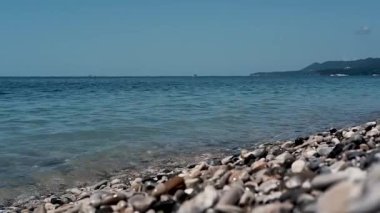 Küçük dalgalar kıyıya vuruyor. Pebble plajı, yaz tatili. Tatilde denizde temiz ve sessiz. Karadeniz kıyısı, Rusya.