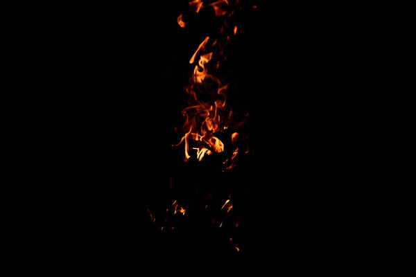 Bright firelight on a black background. The fire on a long exposure. Sparks and flames.