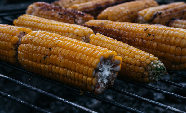 Жареная кукуруза на огне. Горячая сладкая кукуруза. Здоровое питание для вегетарианцев. Ухо кукурузы.