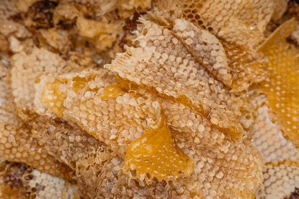 薄薄的蜂蜜堆在一起 大量的蜂蜡和蜂蜜在上面 从蜂箱的框架中取出蜂蜜后的残留物 养蜂业蜂窝的质感 — 图库照片