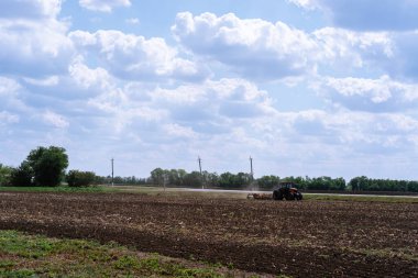 Ekin ekmeden önce tarlayı sürmeyi ve sürmeyi birleştirir. Bir traktör tarlayı sürer. Tarım, tarım ve tarım. Kırsal günlük yaşam.