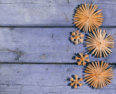 Güzel leylak rengi Noel arkaplanı, el yapımı Noel ağacı oyuncakları ve kar taneleri. Ahşap Noel arka planı, üst manzara. Yeni yılın arka planında metin için yer.