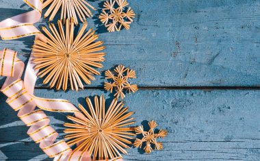 Samandan kar taneleri ve pembe kurdeleli güzel mavi Noel arkaplanı. Ahşap Noel arka planı, üst manzara. Yeni yılın arka planında metin için yer.