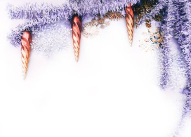 Beyaz arka planda Noel süsleri ve buz saçağı şeklinde Noel oyuncakları. Güzel yeni yıl ve Noel arkaplanı ve harf ve tasarım için bir sürü boş alan.