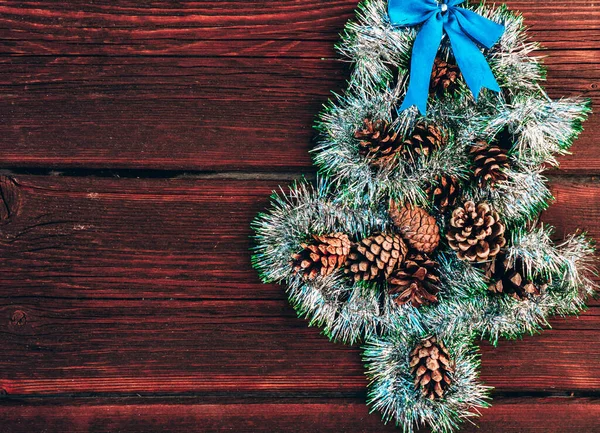 Glänsande Grön Tinsel Form Julgran Med Kottar Och Blå Rosett — Stockfoto