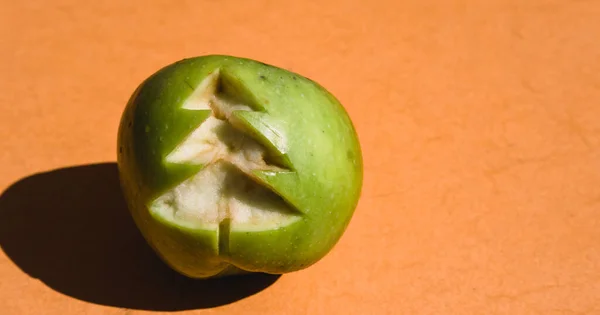 Ein Frischer Grüner Apfel Mit Einem Geschnitzten Weihnachtsbaum Auf Orangefarbenem — Stockfoto