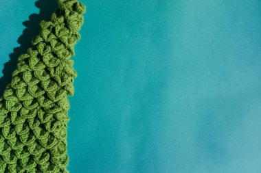 Açık mavi arka planda el yapımı bir Noel ağacı. Güzel minimalist Noel arkaplanı ve harf ya da tasarım için bir sürü boş alan.