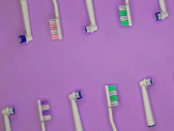 A lot of toothbrushes lie on purple background with copy space. Top view, flat lay. Minimal concept — Stock Photo, Image