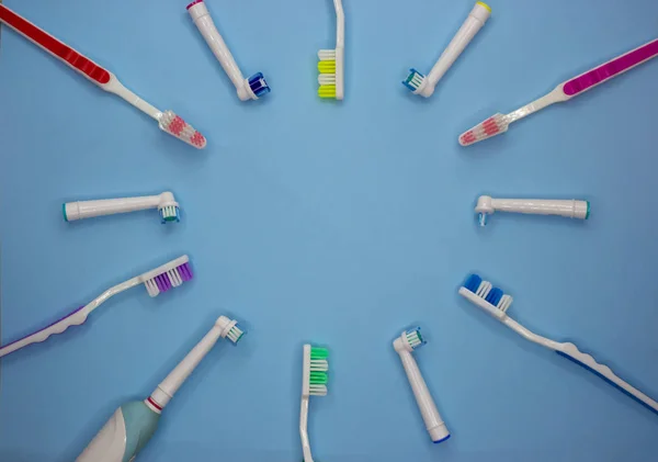 Multicolored toothbrushes on a blue background with copy space. Flet lay. Top view. — Stock Photo, Image