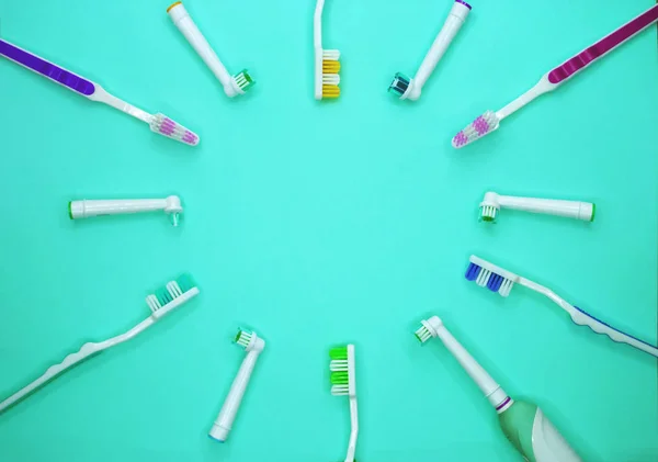 Multicolored toothbrushes on a turquoise background with copy space. Flat lay. Top view. — Stock Photo, Image