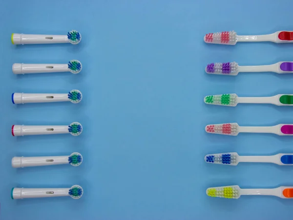 Muitas escovas de dentes clássicas e elétricas estão em um fundo azul pastel com espaço de cópia. Vista superior. Deitado. Conceito mínimo — Fotografia de Stock