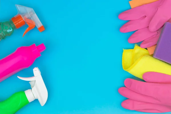 Colorful cleaning set for different surfaces in kitchen, bathroom and other rooms. Empty place for text or logo on blue background. Cleaning service concept. Early spring regular clean up. Top view.