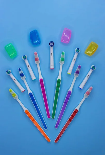 Vícebarevné zubní kartáčky na modrém pozadí. Rovně ležet. Pohled shora. — Stock fotografie