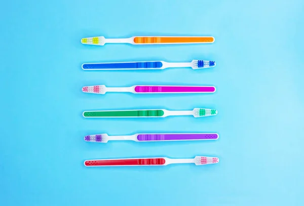 Cepillos de dientes multicolores sobre fondo azul. Acostado. Vista superior . — Foto de Stock