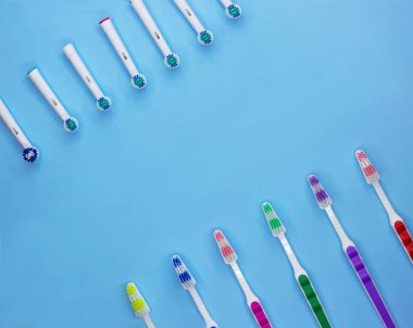 Klasik ve elektrikli diş fırçaları bir sürü kopya alanı ile bir pastel mavi arka plan üzerinde yalan. Üst te. Düz yatıyordu. Minimal konsept