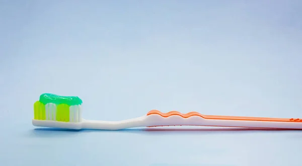 Dental brush with toothpaste on blue background. — Stock Photo, Image