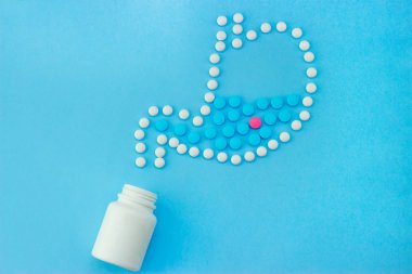 Stomach made of white pills with some red and blue pills inside. clipart