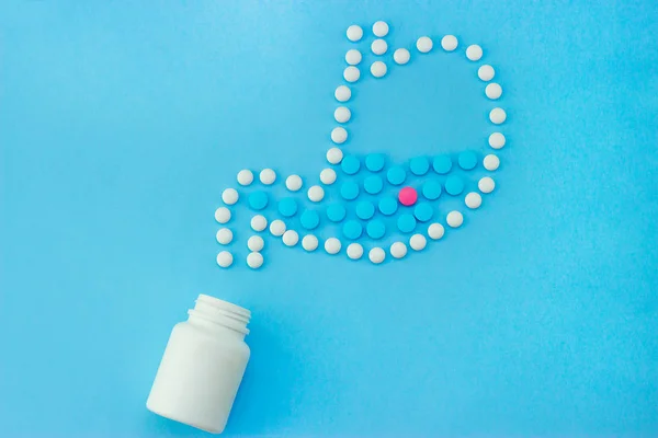 Magen aus weißen Pillen mit einigen roten und blauen Pillen darin. — Stockfoto
