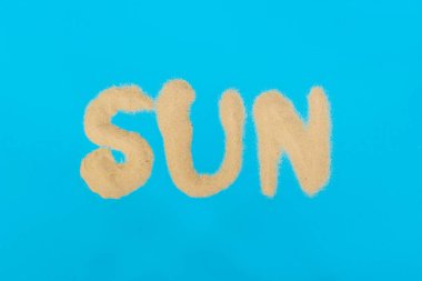 Mavi bir arka plan üzerinde kumdan yapılmış Yazıt Güneş