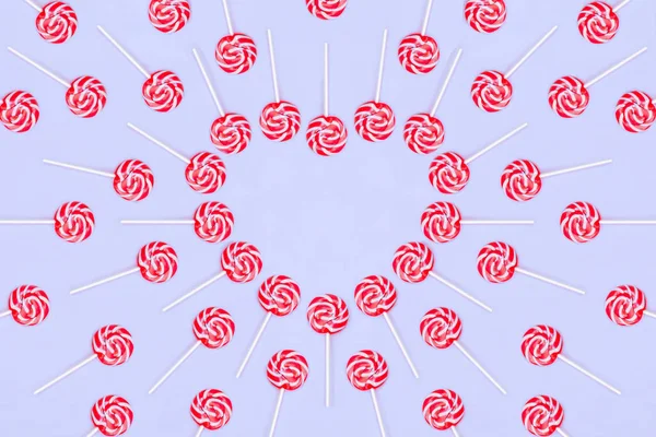 Serce wykonane z czerwonych Lollypop cukierki na niebieskim tle, przestrzeń kopiowania. Walentynkowa karta okolicznościową — Zdjęcie stockowe