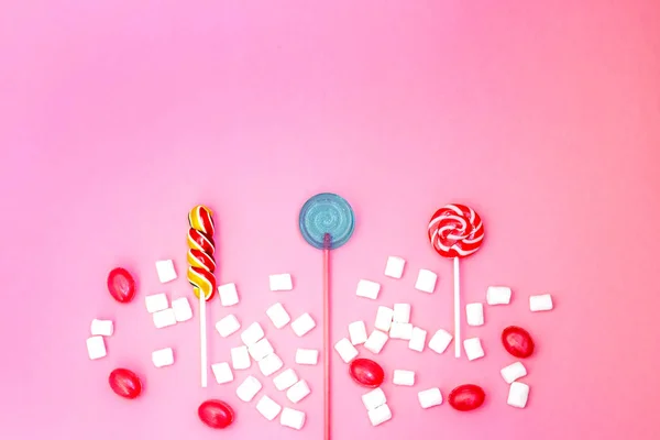 Flat lay composition with yummy lollipops and marshmallows and space for text on pink background — Stock Photo, Image